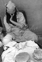 Image du Maroc Professionnelle de  Une femme étale ses pains sur une petite table en bois sur la fameuse place Jemaa El Fana, elles était très nombreuses jadis au centre de Marrakech, 30 Octobre 2006. (Photo / Abdeljalil Bounhar)